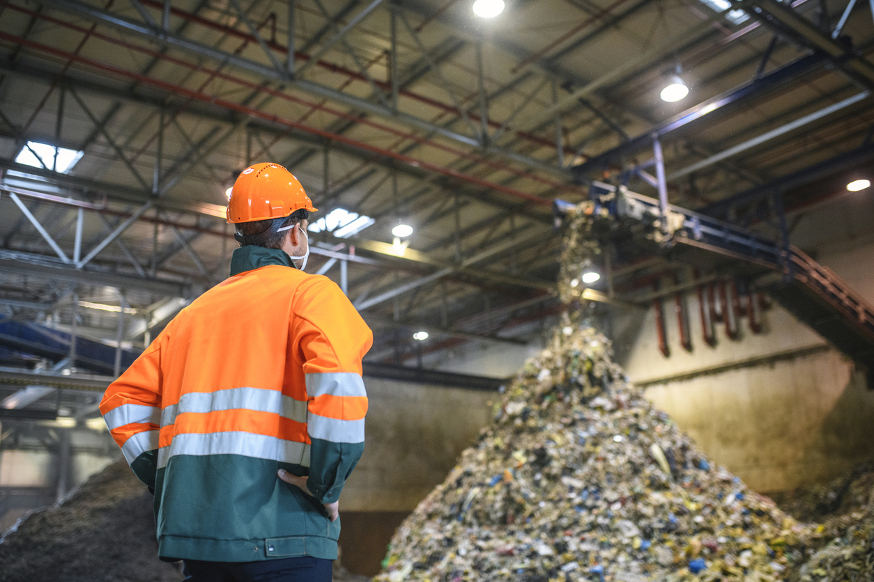 Worker Observing Processing of Waste at Recycling Facility