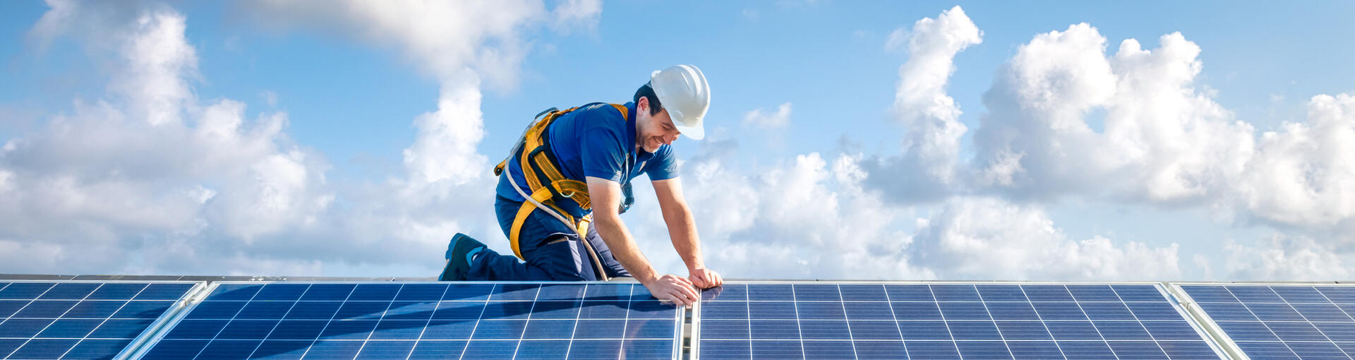 Professional worker installing solar panels on the roof of a house 