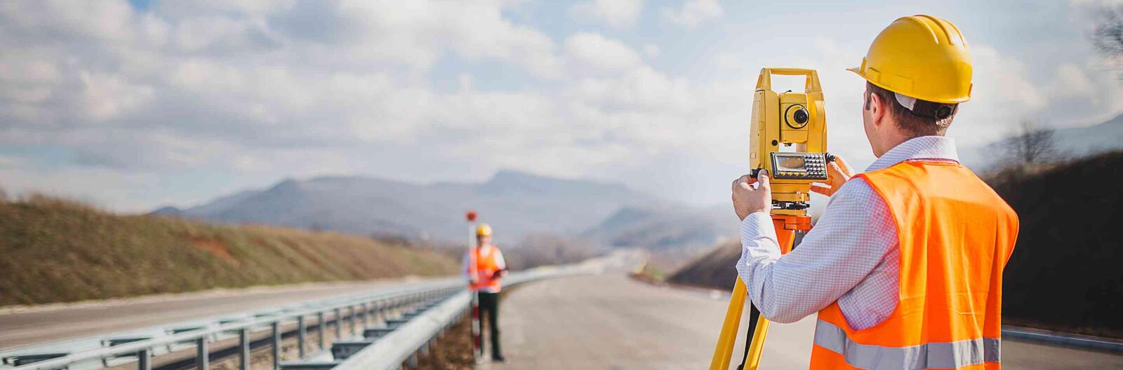 Man in Orange Hi-Vis vest surveying landscape 